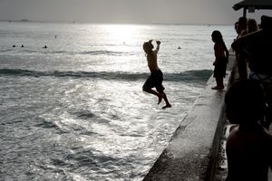Children jumping into Waikiki Beach