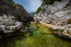 Green clear river flow between rocks