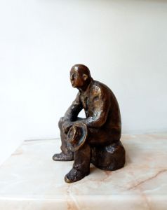 Sculpture of a seated man with a hat